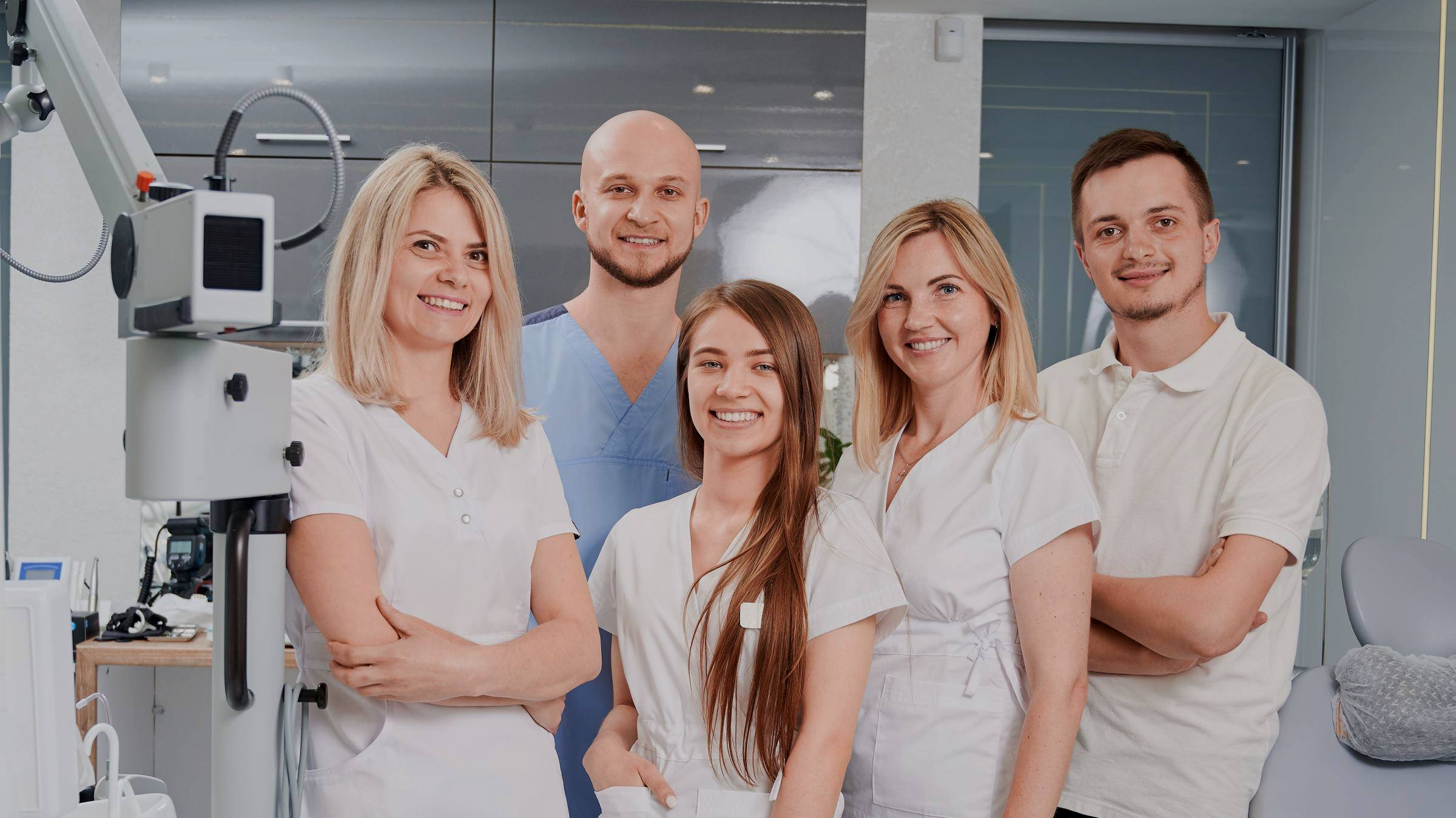 The staff of a dental practice standing together in their treatment room.